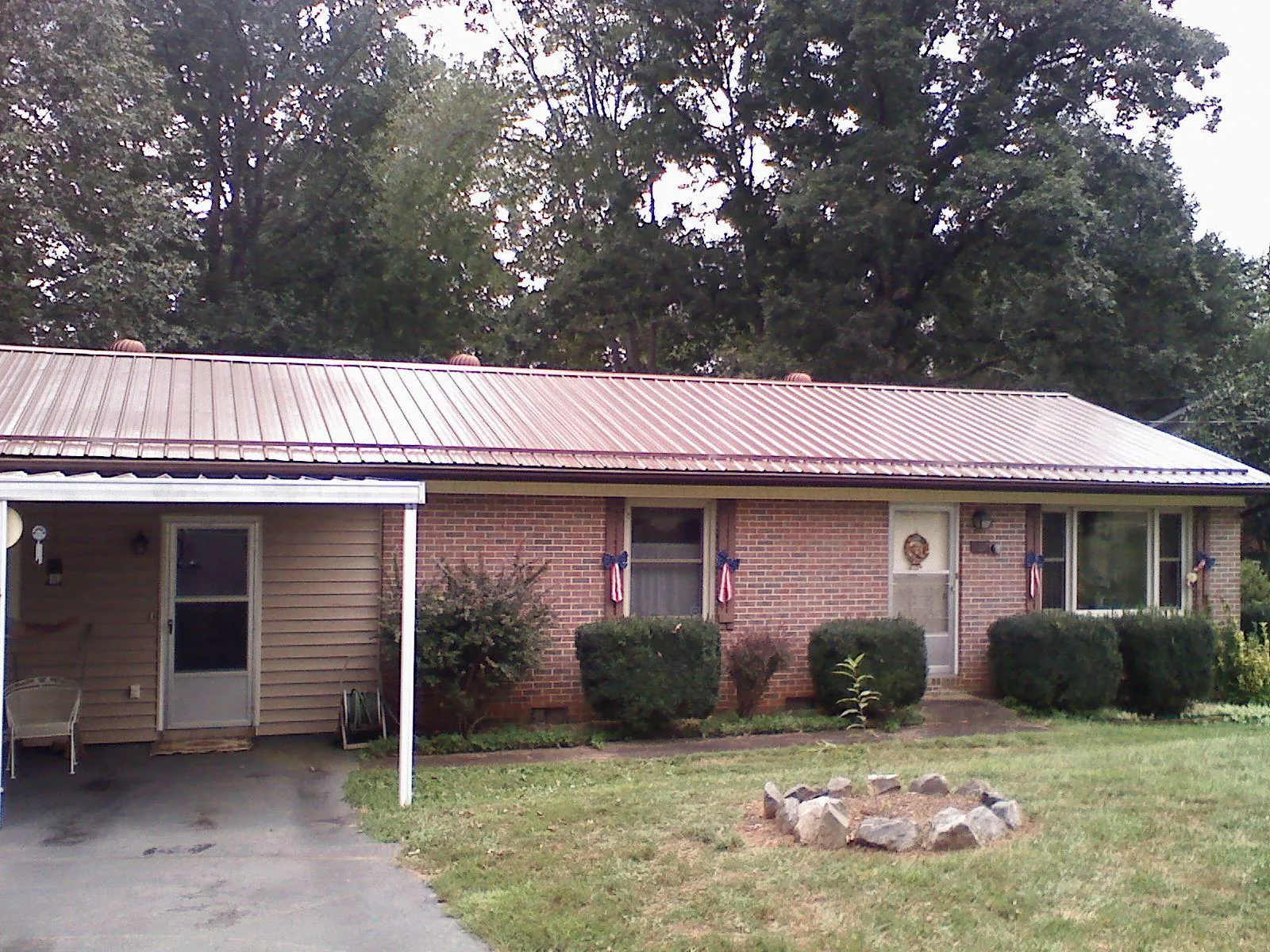 Bronze metal roof and carport on a brick ranch home — Roof Repair work by our crew in West Milton